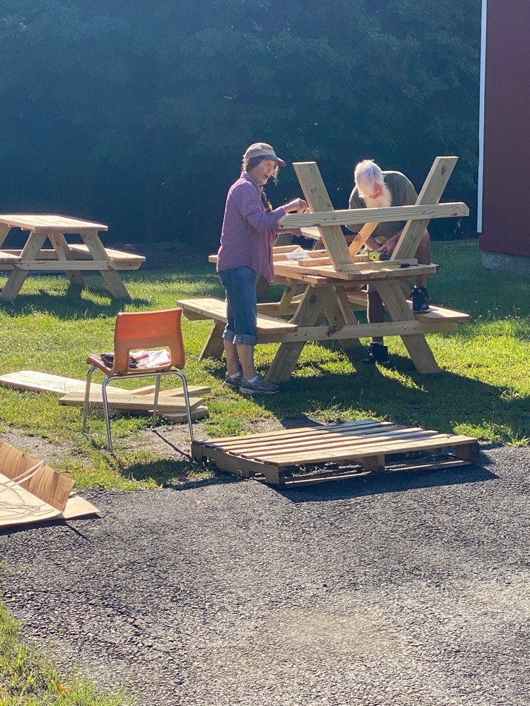 two people assembling a picnic table.